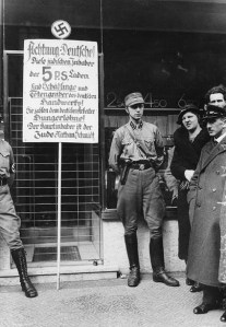 Although by 1934 Germany had become a one-party state under Nazi rule, the increasingly reckless SA violence directed against Jews, communists, socialists and other dissidents began to offend the traditional German sense of civic order, especially in the senior leadership of the army.[1] The sign reads: "Attention Germans! These Jewish owners of the 5 P.S. shops are the parasites and gravediggers of German trade! They pay German workers starvation wages! The principal owner is the Jew Nathan Schmidt."